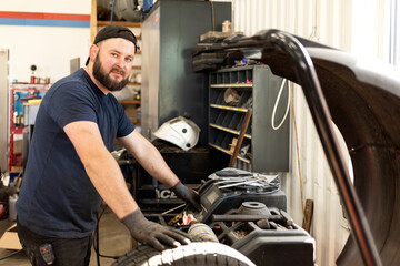 Mechanic using machinery at auto repair shop