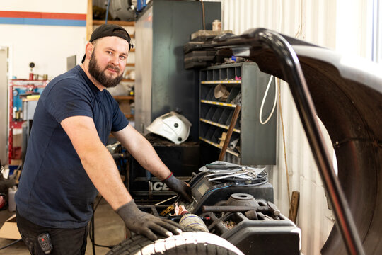 Mechanic using machinery at auto repair shop