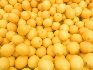 food background with fresh yellow lemons in market