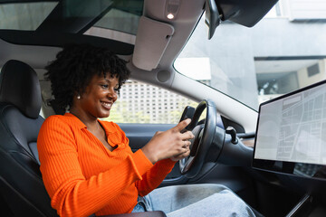 Smiling woman using smart phone and sitting in car at street