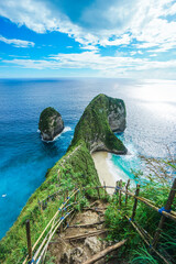 Tropical beach with green cliffs, ocean and sunshine in Kelingking Beach, Nusa Penida, Bali. © Balnyes Visuals