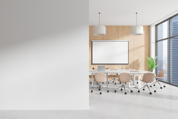 Modern office meeting room in bright open space. Features a blank wall, wooden accent wall, large...