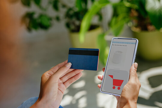 Woman holding smart phone and doing online payment with credit card - Powered by Adobe