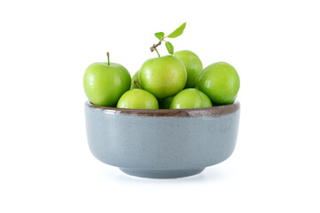 Green plum fruit in ceramic bowl on white background, fruit that pregnant women love