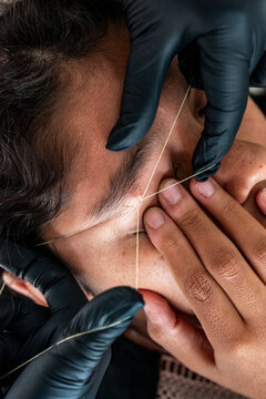 Detailed Eyebrow Threading Session in Progress