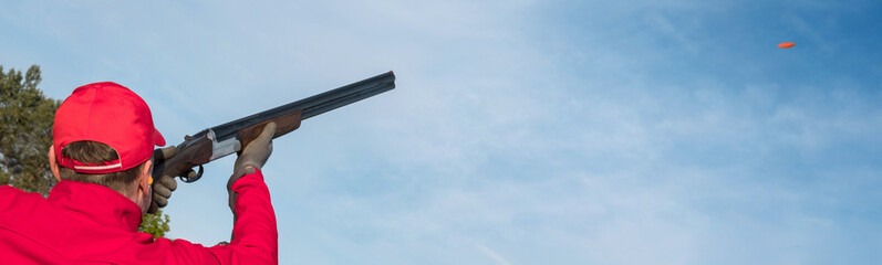  clay pigeon shooting in a shooting club, clay pigeon shooting on a trap with a gun, a man shoots clay pigeons outdoors, banner © Alex