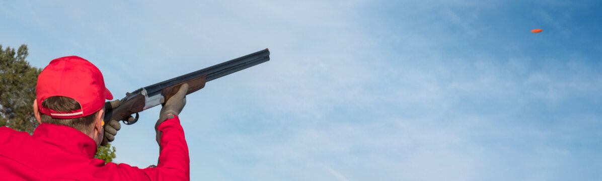  clay pigeon shooting in a shooting club, clay pigeon shooting on a trap with a gun, a man shoots clay pigeons outdoors, banner