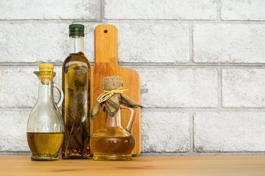 Fototapeta Three bottles of Olive oil on grey bricks background