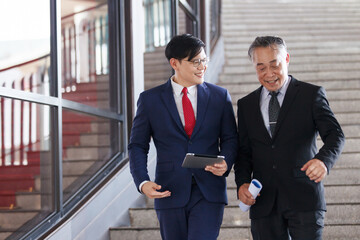 Two Asian businesspeople having a business discussion in the office building.