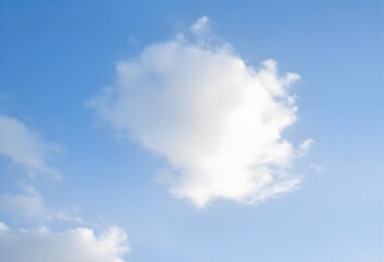 Fototapeta premium Clear blue sky with a single, fluffy white cloud drifting across it