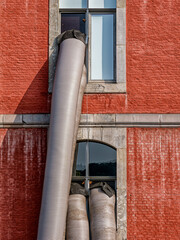 Pipes dangle from a Stavelot window