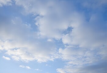 Fototapeta premium Clear blue sky with fluffy white clouds drifting slowly