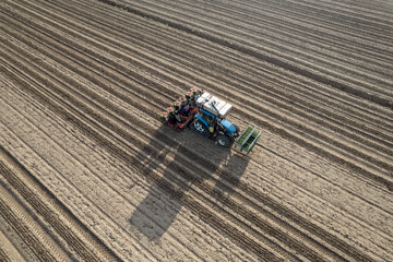 Aerial view of Automatic tomato crop planter machine working in a  harrowed field