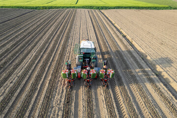 Aerial view of semi Automatic tomato planter machine and agricultural workers working in a field