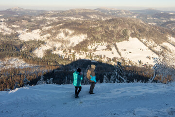 A couple of tourists are walking on the snowy mountains