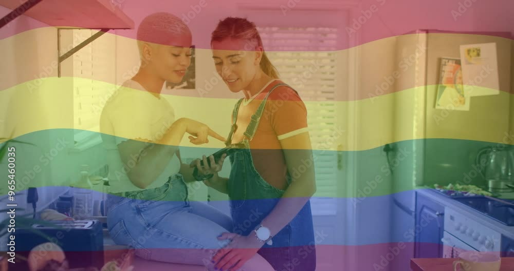 Wall mural Animation of rainbow flag over diverse female couple using smartphone