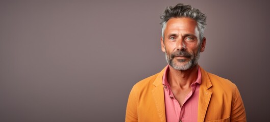 Obraz premium A man with a beard and gray hair is wearing a bright orange jacket