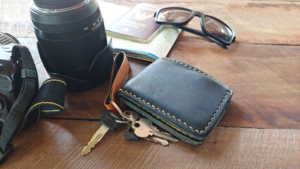Prepare your camera, photography lenses, glasses, wallet, passport on the wooden floor to check off your travel preparation list.