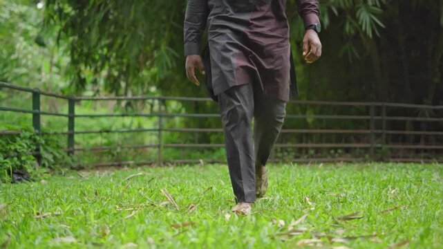 Yoruba male model Walking in the garden wearing snakeskin slippers.
 
