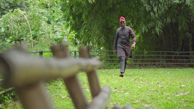 Full frame of a confident walking and smiling Yoruba business man.
