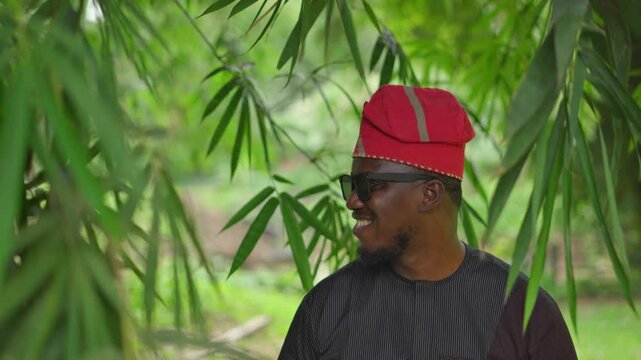 Panning shot of Yoruba man smiling outdoor.