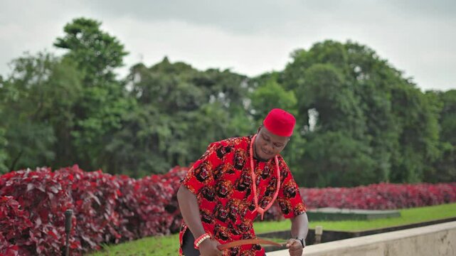 Red cap chief of the Igbos in Nigeria in a fast traditional dance and 3 handshake mantle greeting.
