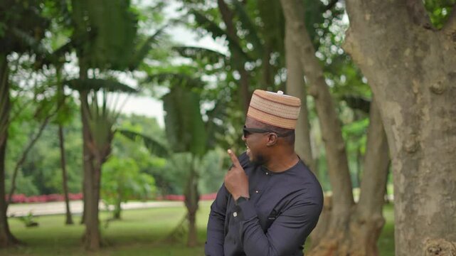 A young Nigerian man joyfully presents imaginary product on two-third of the screen with double thumbs up and finger pointing