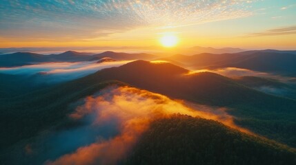 Golden sunrise illuminating rolling hills with fog