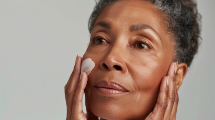 Healthy-skinned woman in her 50s using serum