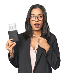 Young Latina in business suit with passport pointing to the side