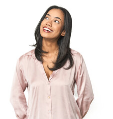 Simple portrait of a young Latina relaxed and happy laughing, neck stretched showing teeth.