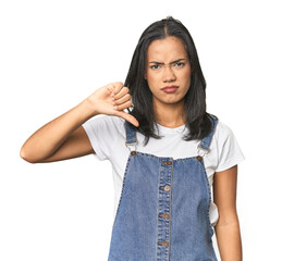Simple portrait of a young Latina showing thumb down, disappointment concept.