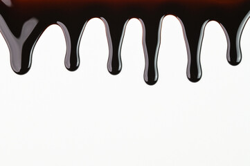 Chocolate syrup dripping on a white background.