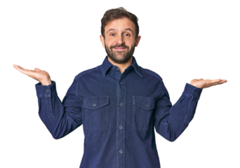 Studio portrait of young Hispanic male makes scale with arms, feels happy and confident.