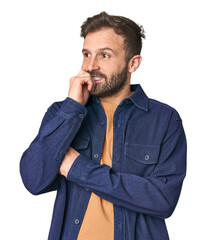 Studio portrait of young Hispanic male relaxed thinking about something looking at a copy space.