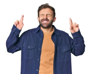 Studio portrait of young Hispanic male crossing fingers for having luck