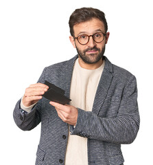 Hispanic male businessman holding wallet in studio