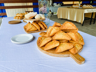 A beautifully crafted wooden cutting board showcases an array of delightful pastries artfully arranged on a lovely table, allowing everyone to easily access and enjoy these treats