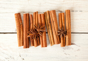 Cinnamon quills and star anise on rustic wooden table closeup