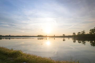 Gravel path running along lake shore at sunset with golden light, Po River, Piaceza, Italy