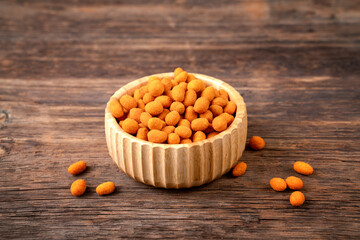 Peanut chips with sauce in bowl on old wooden table stock photo