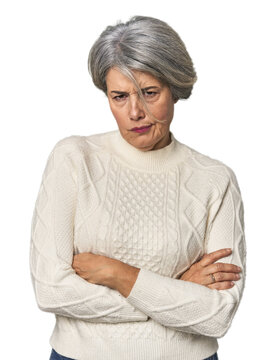 Caucasian mid-age female on studio background unhappy looking in camera with sarcastic expression.