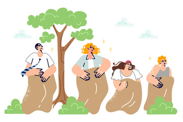 Family participates in sack race together, having fun in their free time in park, in fresh air