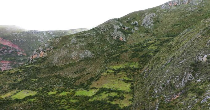 Beautiful aerial drone shot of a vegetated mountain peak during a summer afternoon.