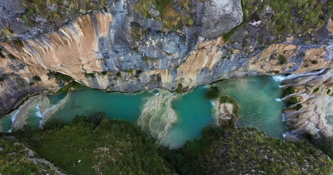 Amazing drone shot of the beautiful Millpu lake with turquoise waters in Ayacucho, Peru during an afternoon between rocky mountains and beautiful colors.