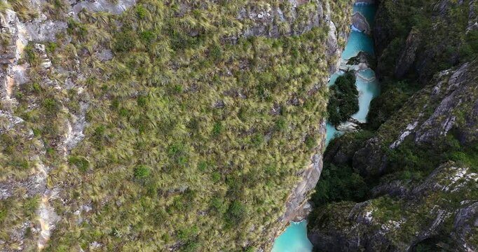 Amazing drone shot discovering a beautiful and magical lake called Millpu with turquoise waters during a morning located between mountains with vegetation in Ayacucho, Peru.