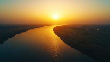 Hazy sunset over a calm river, humid weather, golden hour light