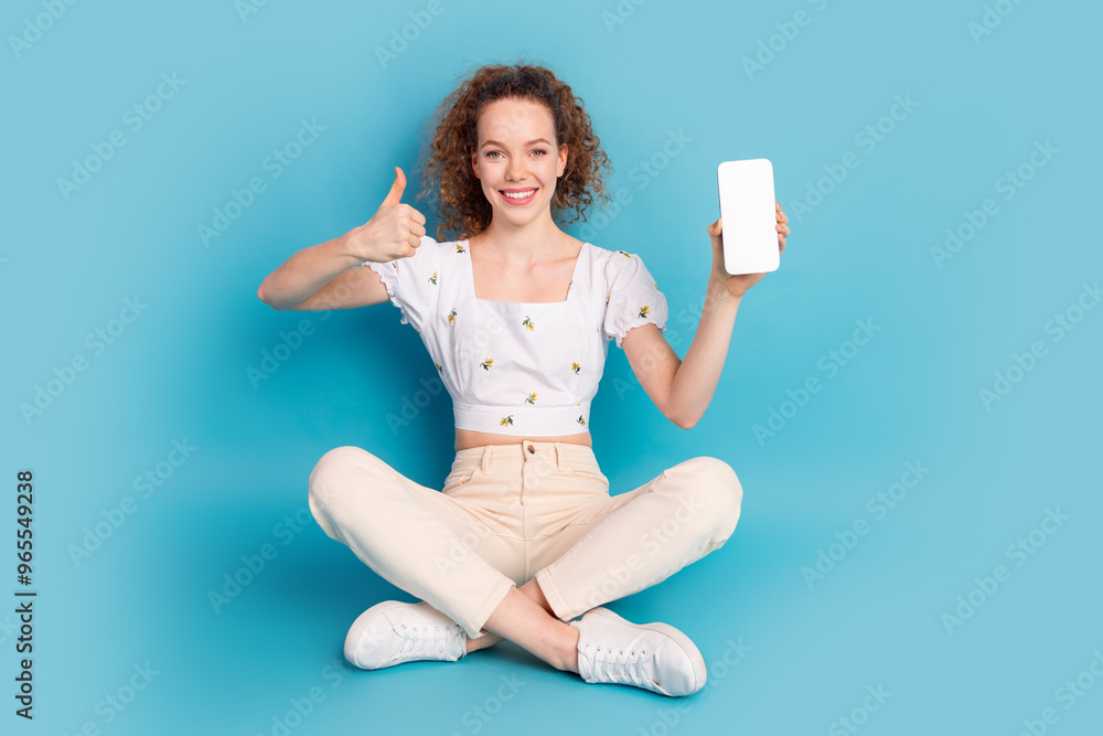 Poster Full length photo of lovely young lady sit floor gadget qr code thumb up dressed stylish white garment isolated on blue color background