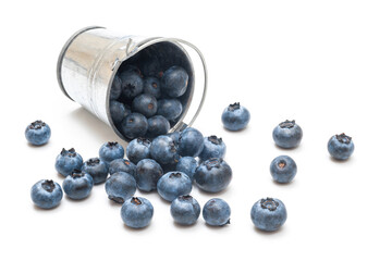 Blueberries spilling from a bucket on a white background.