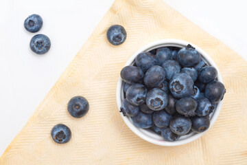 Fresh blueberries in a bowl on a table, top view